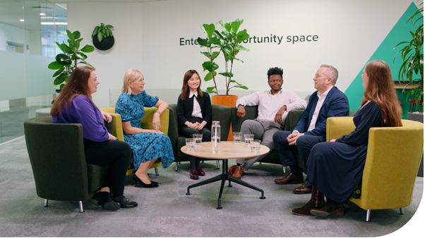 Mott MacDonald people in open break out space seated.