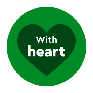 This image features a circular graphic set against a plain white background, following the same style as the previous graphic.  Design Elements: A bright green circular backdrop contains a solid dark green heart silhouette placed centrally within it.  Text & Typography: Bold white text in a rounded, clean sans-serif typeface is layered over the heart silhouette. The word "With" is rendered in a smaller size near the top of the heart, with "heart" displayed directly below it in a larger, lowercase font.  Colour Scheme: A high-contrast palette consisting of bright green, dark green, and crisp white.