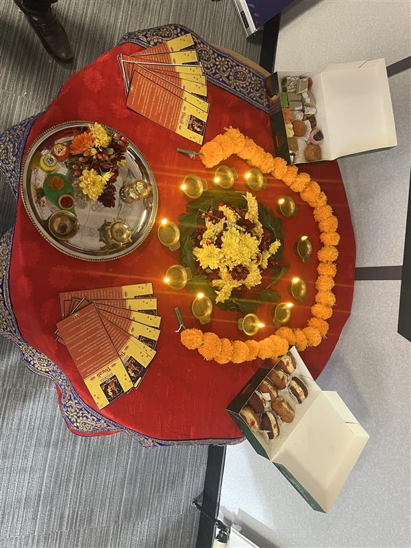A table with a red tablecloth and diwali decorations and food