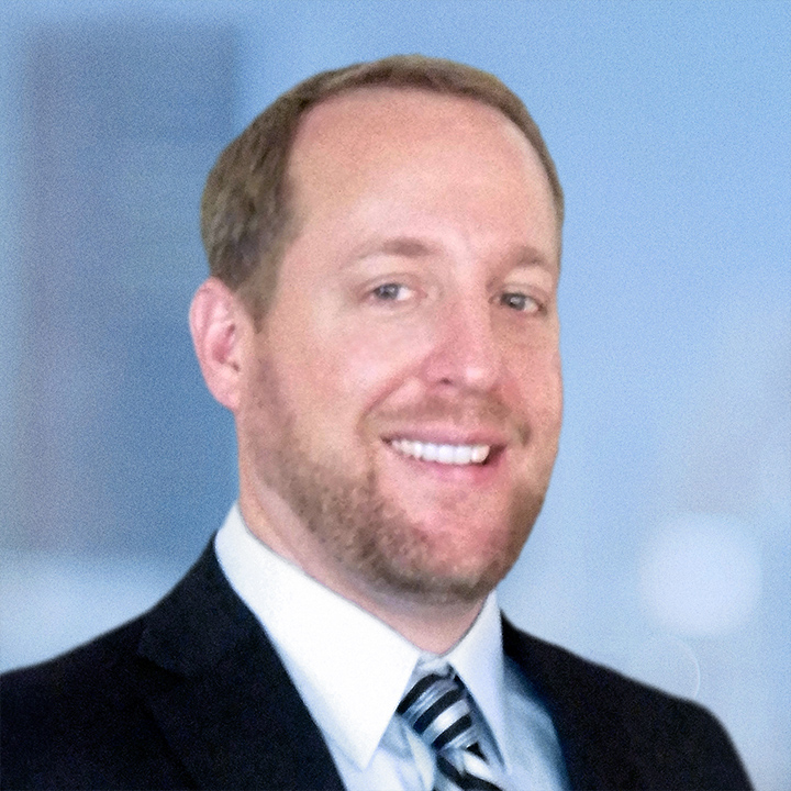 Jarrett Kinslow, a white male with brown haor and eyes wearing a white shirt and a striped tie