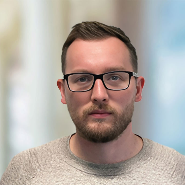 Neil Mason a whote male with brown haor and blue eyes wearing glasses and a brown top