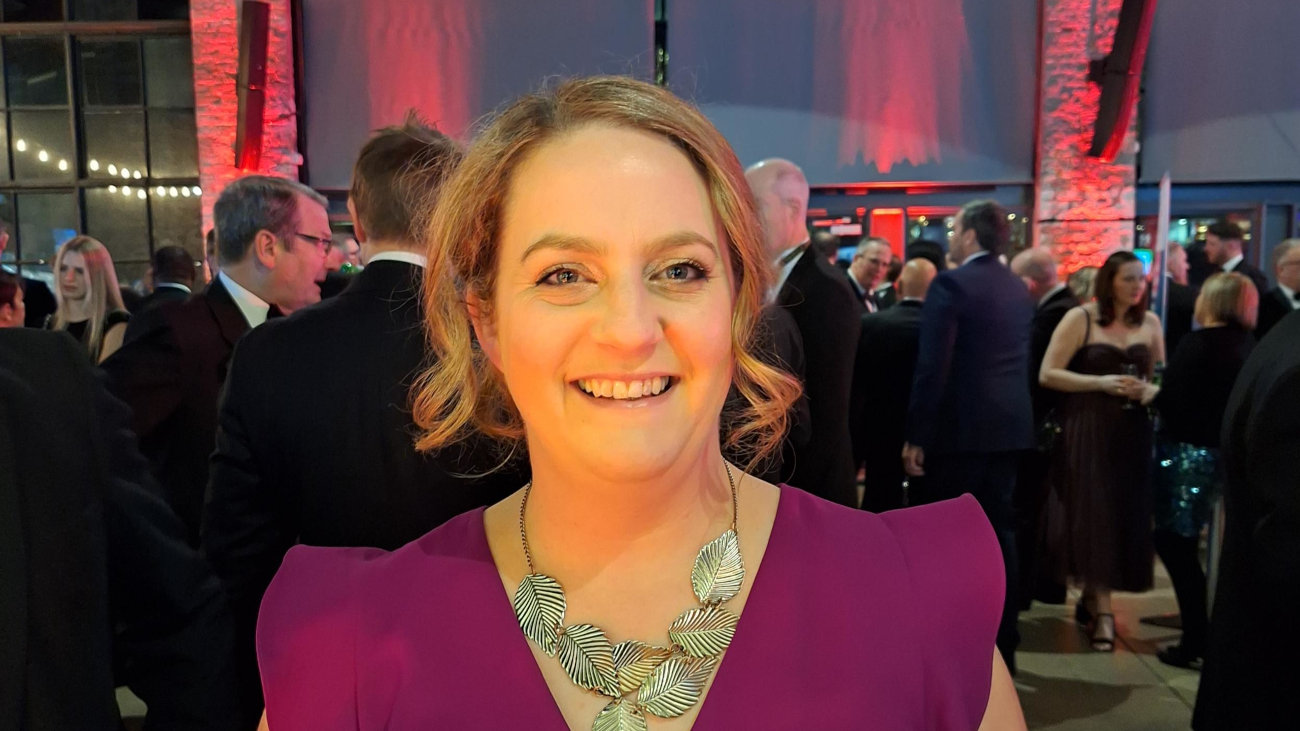 Ruth Shilston a middle aged white women wearing a purple dress and silver leaf necklace