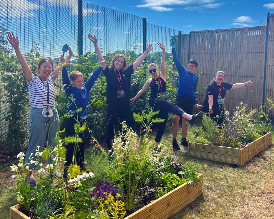 A group of Jacobs employees jumping in a garden