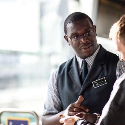 African male GWR staff member assisting a passenger