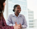 Black female sat at a desk smiling
