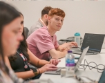 A group of employees sitting at desks in a classroom setting