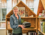 A white women holding a Habitat product standing between a Habitat display