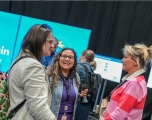 Three white women standing facing each other and talking