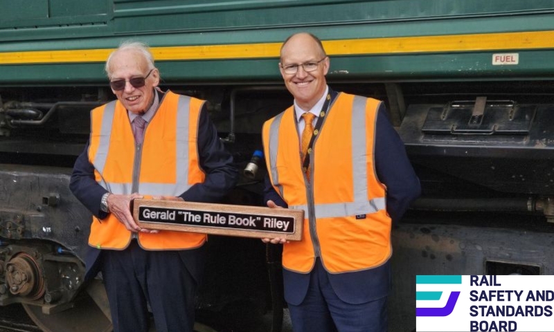 Gerald Riley and collegue standing in front of a freight train