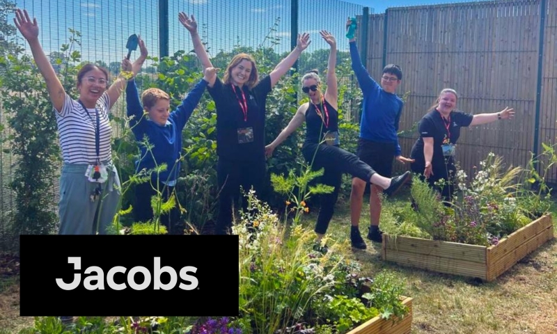 A group of Jacobs employee jumping in a garden