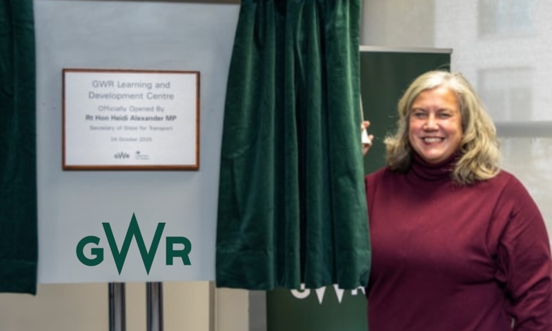 a white woman, the mayor, wears a maroon polo neck topk