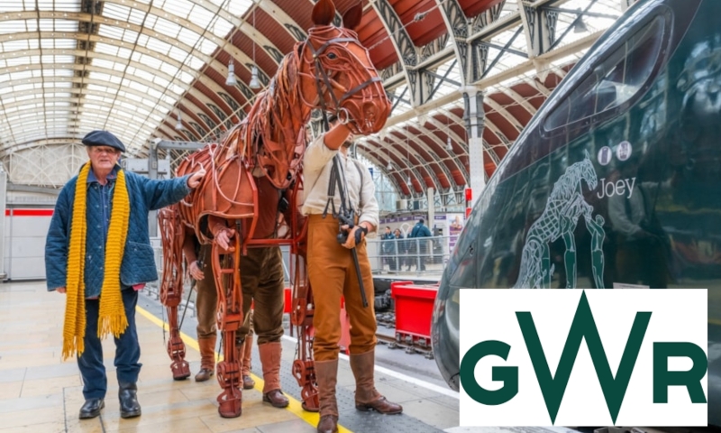 Michale walking with his horse puppet in a train station