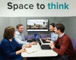 Four people sitting in an office with a sign above them saying 'space to think'