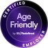 The image is a circular badge or seal featured in shades of deep purple, black, and white:  Shape & Structure: It consists of a round badge with a dark outer border and a gradient purple inner circle, giving it a subtle 3D or bevelled appearance.  Text Content:  Curved around the top half of the outer border in bold, uppercase white letters is the word "CERTIFIED".  Curved around the bottom half of the outer border in the same style is the word "EMPLOYER".  At the center of the inner circle, the main text reads "Age Friendly" written in prominent white, sans-serif typography across two lines.  Beneath "Age Friendly", in smaller white font, is the attribution line: "by 55/Redefined".