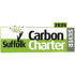 The image displays a rectangular certification logo for the Suffolk Carbon Charter.   Key design features include:Text: The words "Suffolk Carbon Charter" are prominently displayed in a bold sans-serif font. "Suffolk" and "Carbon" are rendered in black text, while "Charter" appears in white against a bright green background block.   Imagery: On the left side, a black graphic resembling a tree trunk with a hand-like branch reaches upwards towards a scatter of small, light-green leaves floating above it.   Level and Date: Positioned on the right edge is a vertical grey banner reading "SILVER" in white capital letters. Directly above this banner, the year "2026" is printed in black inside a small green box.   Colour Scheme: The layout uses a clean palette of lime green, black, white, and grey, divided horizontally between a white upper half and a green lower half.