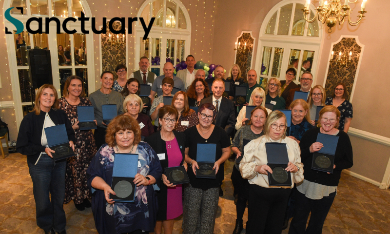 Sanctuary colleagues holding engraved glass plaques at their 25-year long service celebration